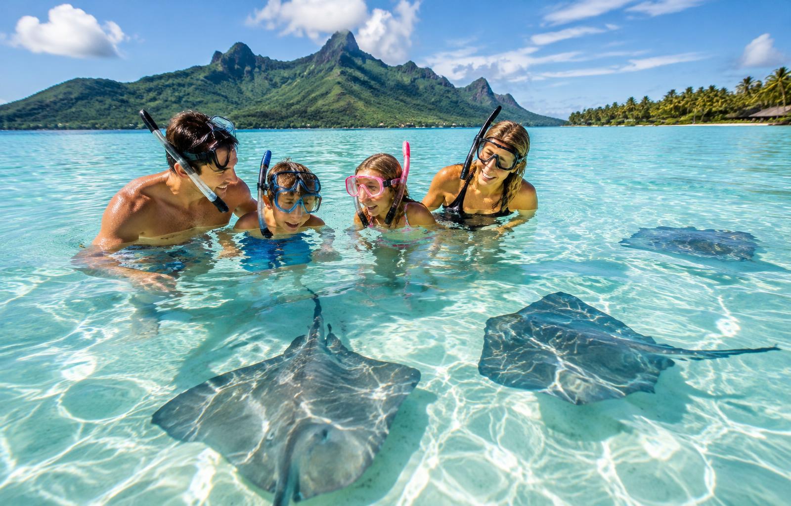 Famiglia fa snorkeling con le razze nella laguna di Moorea