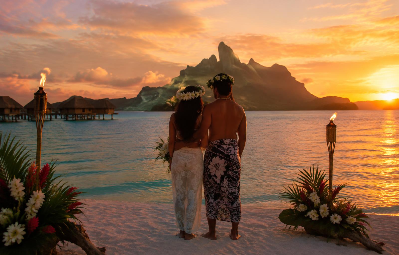 Coppia al tramonto durante una cerimonia polinesiana a Bora Bora